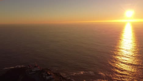 Aerial-reveal-cape-finisterre-fisterre-rock-formation-famous-for-trekking-to-Santiago-de-Compostela,-drone-footage-sunset