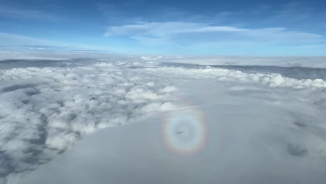 Stunning-view-of-the-halo-of-a-jet-plane,-side-window-wiew-of-the-cockpit,-while-overflying-some-layers-of-stratus-at-10000-m