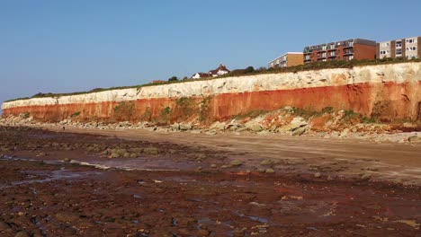 Aerial-view-of-Hunstanton's-low-tide-boulder-field,-beach-and-cliffs