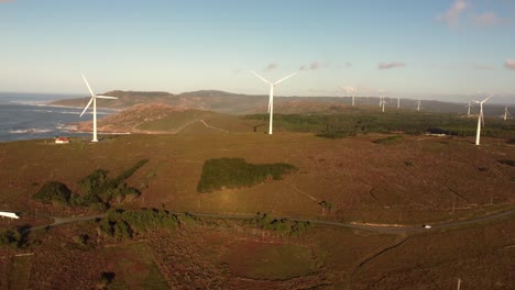 Aerial-view-of-wind-turbine-windmill-plant-over-a-rock-cliff-formation-with-ocean-sea-view,-unpolluted-global-warming-climate-change-concept
