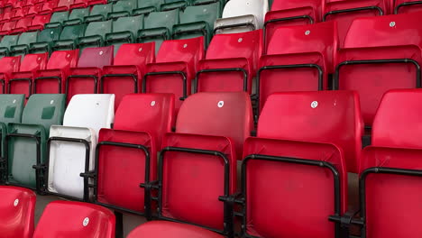 Empty-stadium-with-red-green-and-which-spectator-seats-in-the-sports-stand