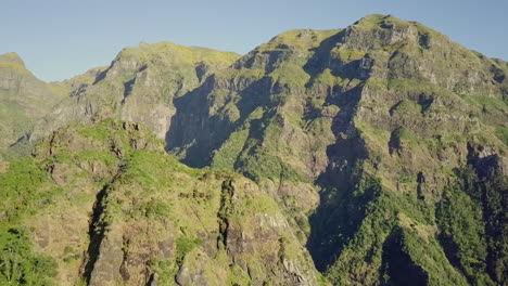 Midday-aerial-moving-through-steep-mountains-on-island-of-Madeira-Portugal