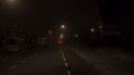 POV-of-car-driving-through-a-calm-neighborhood-on-a-misty-night