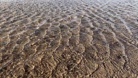Fast-ripples-of-water-shimmering-in-the-wind-on-a-beach-with-the-sand-river-bed