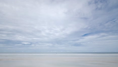 Timelapse-Der-Strand-Mit-Weißem-Sand-Und-Wellen-Vom-Ruhigen-Meer-Bei-Sonnenschein-Tagsüber