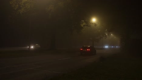 Wide-shot-of-car-driving-over-road-on-a-misty-night