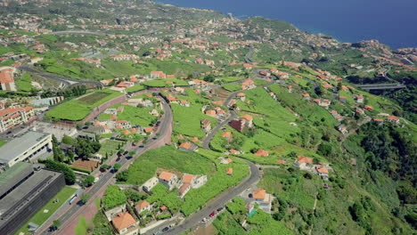 Midday-aerial-view-panning-up-over-houses-on-hillside-of-Madeira-Portugal