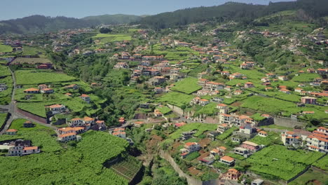 Aerial-panning-down-rural-hillside-terrace-community-on-Madeira-Portugal
