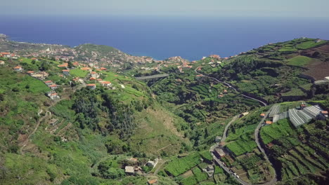 Aerial-panning-down-to-terraced-farming-valley-overlooking-Atlantic-Ocean
