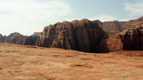 Schöne-Luftdrohnenlandschaftsnatur,-Die-Auf-Einer-Wanderung-Im-Snow-Canyon-State-Park,-Utah,-An-Einem-Warmen-Sonnigen-Sommertag-Einen-Schuss-Von-Atemberaubenden-Roten-Felsformationen-Mit-Getrockneten-Versteinerten-Sanddünen-Nach-Oben-Kippt