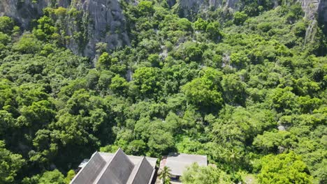 Aerial-reverse-footage-from-the-forest-revealing-the-roofs-of-a-temple-complex
