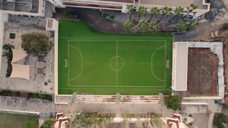 Aufsteigende-Luftaufnahme-Eines-Gesäumten-Fußballplatzes-Neben-Wohnhäusern