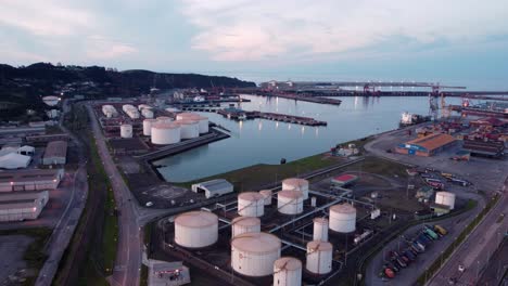 Aerial-View-of-the-commercial-port-harbour-of-Gijon-city-north-of-Spain,-import-and-export-goods-with-container,-sunset-illuminated-at-dusk
