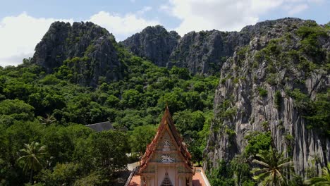 Ascending-footage-revealing-the-staircase-of-the-temple-to-the-top,-the-limestone-mountain-with-blue-sky-and-clouds