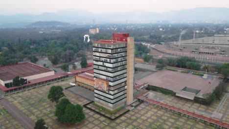 Orbiting-aerial-view-of-an-academic-tower-at-Ciudad-Universitaria,-Mexico-City