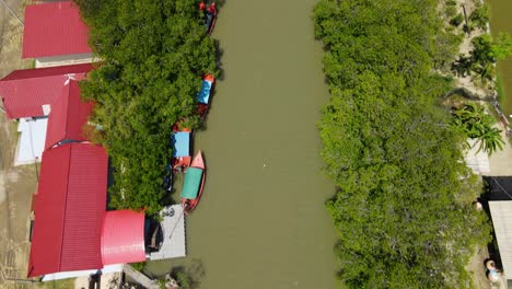 Aerial-footage-revealing-a-bridge,-the-river,-rooftops,-touring-boats,-mangroves
