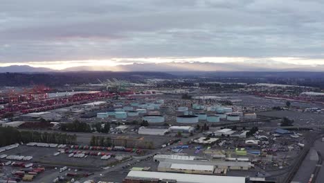 Puerto-De-Tacoma-Contra-El-Cielo-Nublado-Durante-El-Amanecer-En-Tacoma,-Washington---Panorámica-Aérea
