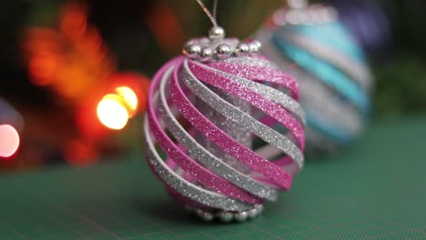 Pink-and-blue-glitter-foam-christmas-ornaments,-on-a-green-cutting-mat