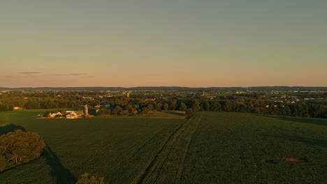 Eine-Luftaufnahme-Von-Amish-Farmen-Und-Feldern-Während-Der-Goldenen-Stunde-An-Einem-Spätsommernachmittag