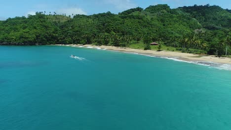 Aerial-View-Of-Blue-Sea-And-Playa-Colorado-With-Tropical-Trees-On-A-Sunny-Summer-Day-In-Dominican-Republic