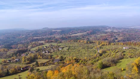 european-rural-landscape-with-forests,-fields-and-houses-seen-from-above,-pan-right