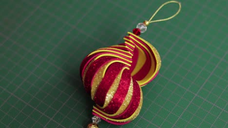 Red-and-gold-glitter-foami-christmas-ornament-on-green-cutting-mat