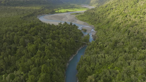 Hokitika-Gorge-vibrant-blue-river-in-green-forest-landscape,-aerial