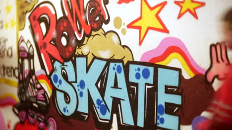 Mädchen-Skaten-An-Einem-Rollschuh-Graffiti-Schild-Auf-Einer-Rollschuhbahn-Vorbei