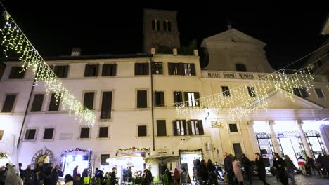 Leute,-Die-Nachts-In-Rom,-Italien,-Mit-Kirche-Und-Kirchturm-Im-Hintergrund-Mit-Einer-Aufbauvideoaufnahme-Spazieren-Gehen
