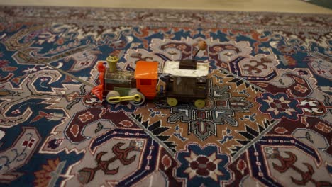 Vintage-toy-train-being-pulled-across-a-carpet---isolated-close-up