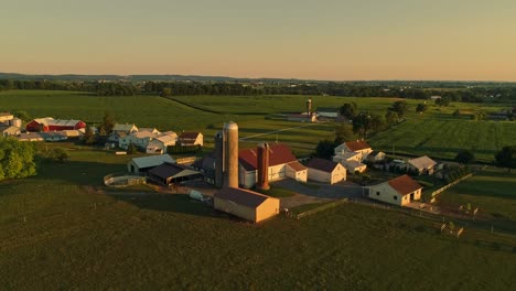 Eine-Luftaufnahme-Von-Amish-Farmen-Und-Feldern-Während-Der-Goldenen-Stunde-An-Einem-Spätsommernachmittag