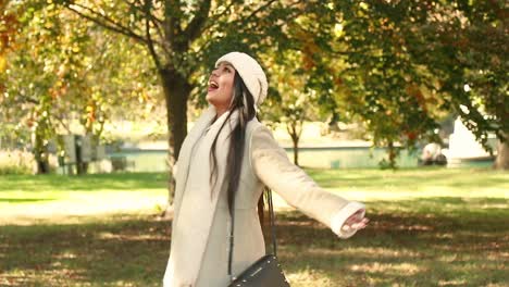 Beautiful-girl-looks-around-at-the-chilly-fall-autumn-leaves-at-a-city-park