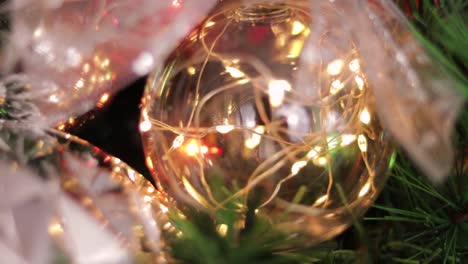 Transparent-christmas-ball-with-lights,-hanging-from-the-christmas-tree
