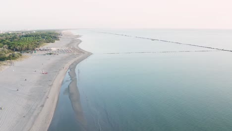 Aerial-view-of-sandy-beach-with-umbrellas,gazebos-and-town