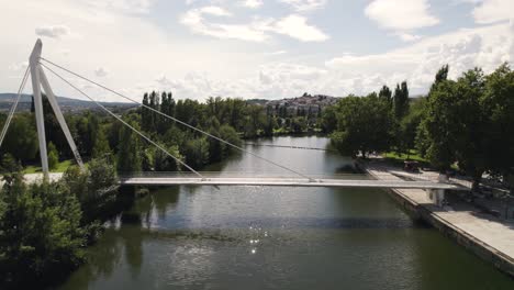 Reveal-shot-of-cable-stayed-pedestrian-bridge-over-tamega-river,-Chaves-Portugal