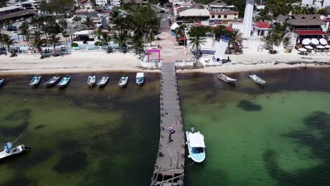 Aerial-view-of-a-beach-town-in-Mexico,-zoom-out-from-boat-dock