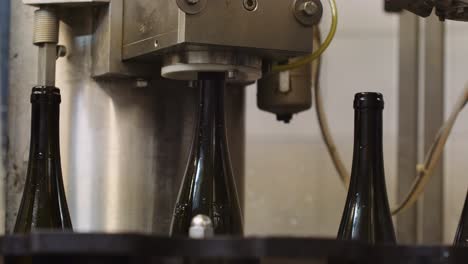 Wine-bottles-lifted-into-corking-machine-to-get-corked