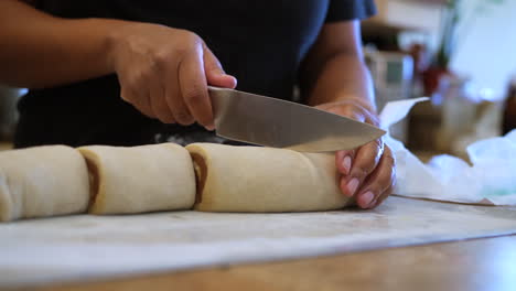 Slicing-cinnamon-roll-dough-with-perfect-swirls-for-baking-and-serving---slow-motion