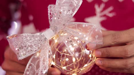 Hands-showing-a-transparent-ball-with-beautiful-lights
