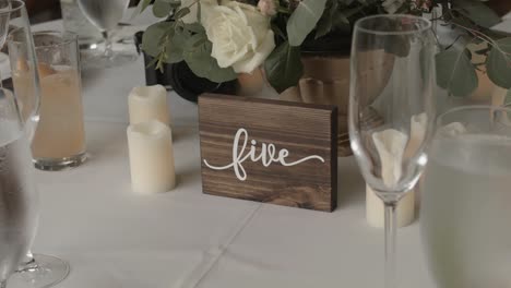 Hochzeitsessen-Mit-Blick-Auf-Holzdekorationen,-Umgeben-Von-Kerzen,-Blumen-Und-Hohen-Gläsern