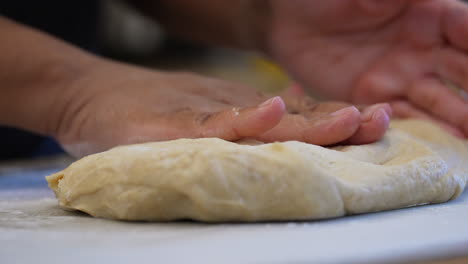 Hand-kneading-dough-for-rolls,-bread,-pizza-or-pastries---isolated-close-up-in-slow-motion