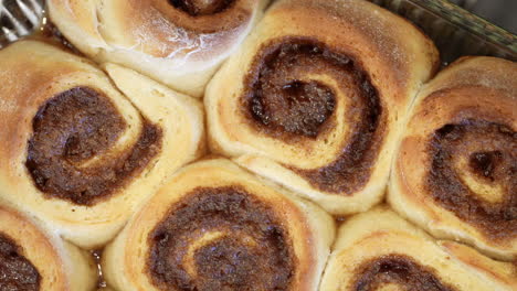 Freshly-baked-cinnamon-rolls-with-the-butter-still-bubbling-from-the-oven---top-down-view-in-delicious-slow-motion