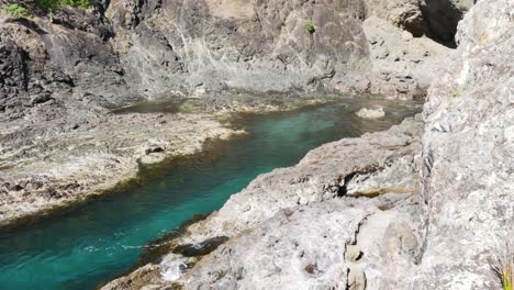 Kristallklarer-Bergfluss,-Der-An-Sonnigen-Tagen-Zwischen-Felsen-Fließt---Spirits-Bay,-Neuseeland---Schwenkaufnahme