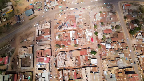Aerial-over-small,-busy-streets-towards-the-main-road-running-through-a-stunning-town-in-rural-Kenya