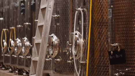 Stainless-steel-wine-tanks-in-cellar-of-winery-ready-for-the-harvest