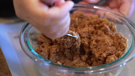 Mixing-brown-sugar,-cinnamon-and-butter-with-a-fork-for-cinnamon-roll-filling---slow-motion