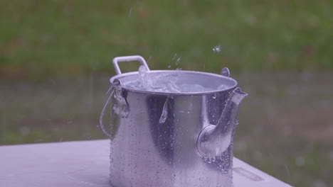 Rainwater-fills-a-kettle-or-billy-outside-during-a-storm