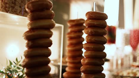 Tower-Stapel-Von-Süßen-Köstlichen-Glasierten-Ring-Donuts-An-Einem-Hochzeitsempfangsbuffet,-Nahaufnahme-Dolly-Out-Shot