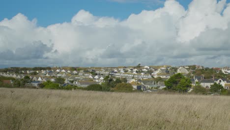 4K-Cinematic-landscape-panning-shot-of-giant-clouds-hovering-over-a-small-island-town,-on-Portland,-Dorset,-in-England,-on-a-sunny-day
