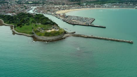 Panoramic-View-Of-Nothe-Fort-And-Harbor-In-Weymouth,-England---aerial-drone-shot